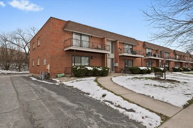 a front view of a house with a yard and car parked