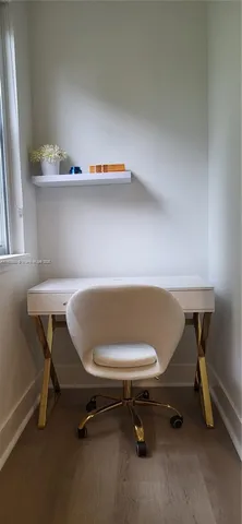 a workspace with a table chair and wooden floor