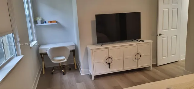 a bathroom with a toilet and a wooden floor