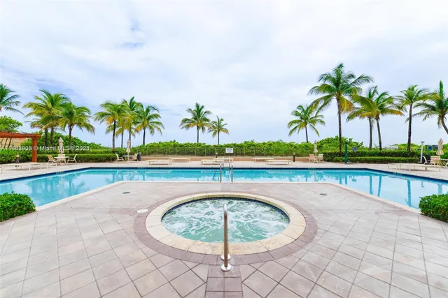 a swimming pool with lawn chairs and a tables