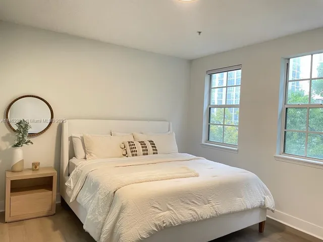 a bedroom with a bed and windows