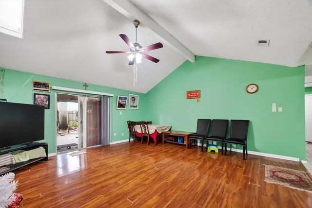 a view of a livingroom with furniture a flat screen tv and wooden floor