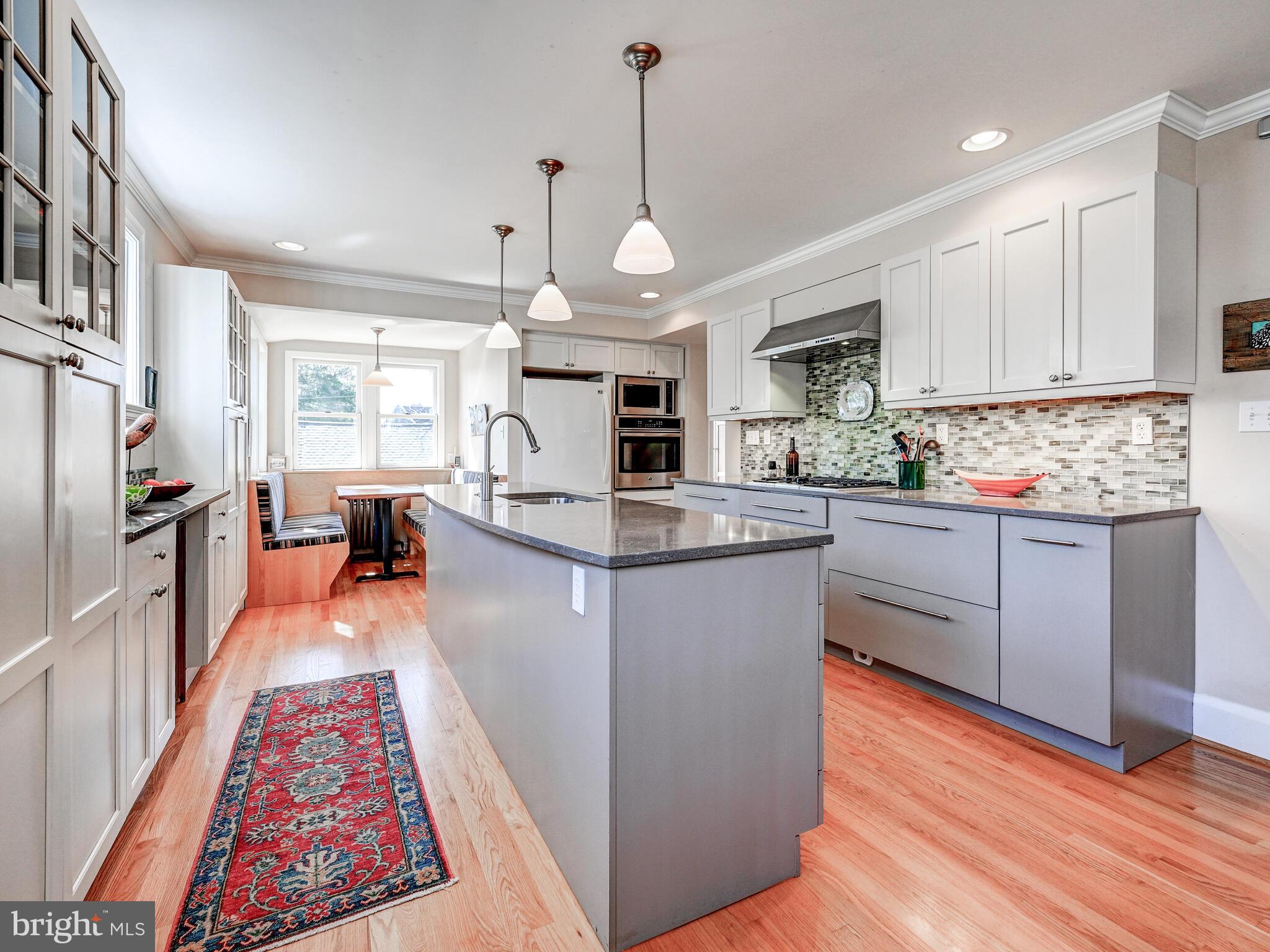 207 Cedarcroft Road Baltimore, MD 21212 - Photo 15 of 50 a kitchen with stainless steel appliances granite countertop a refrigerator a sink dishwasher a stove and white cabinets with wooden floor