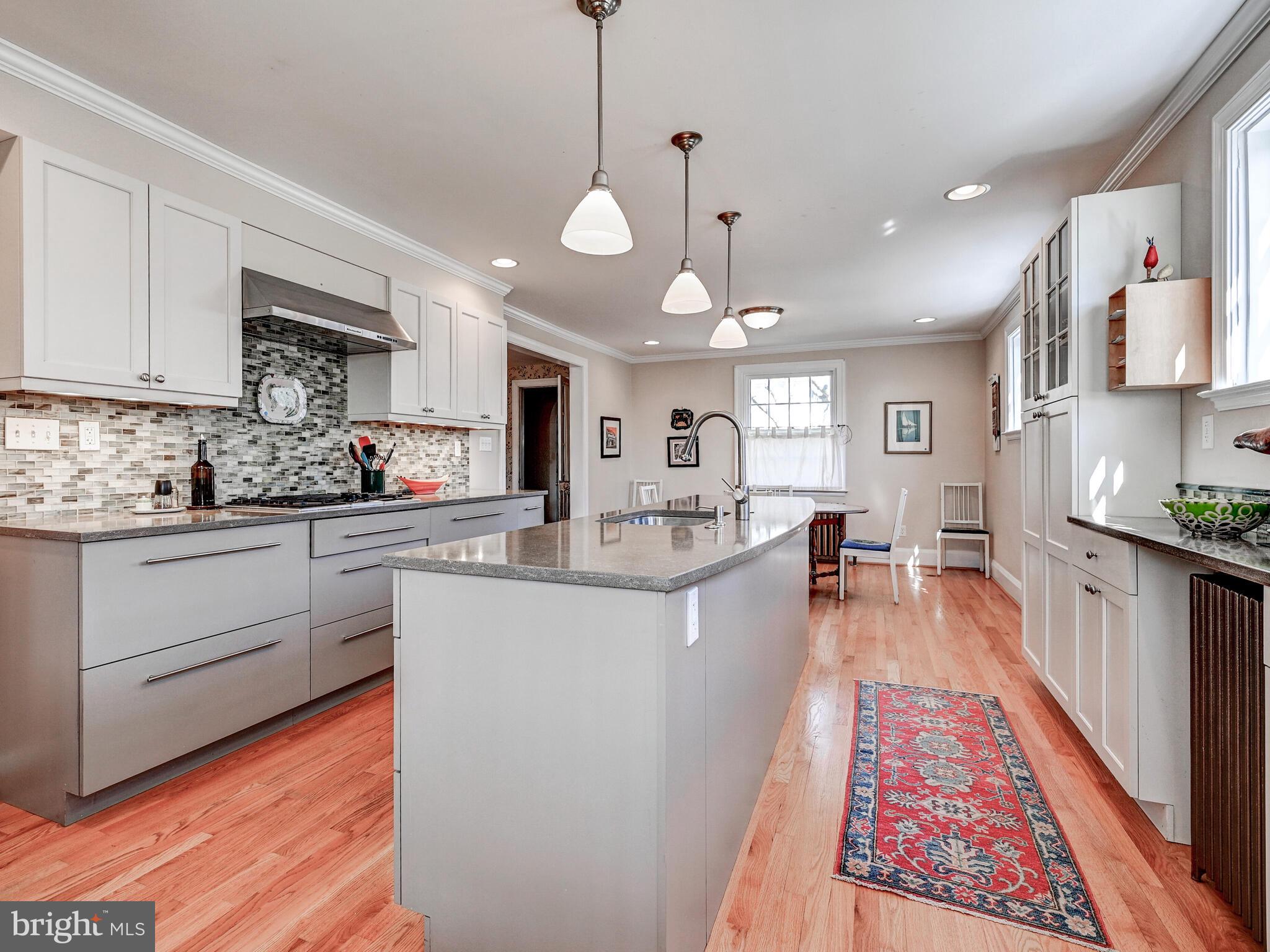 207 Cedarcroft Road Baltimore, MD 21212 - Photo 17 of 50 a large white kitchen with lots of counter space wooden floor and stainless steel appliances