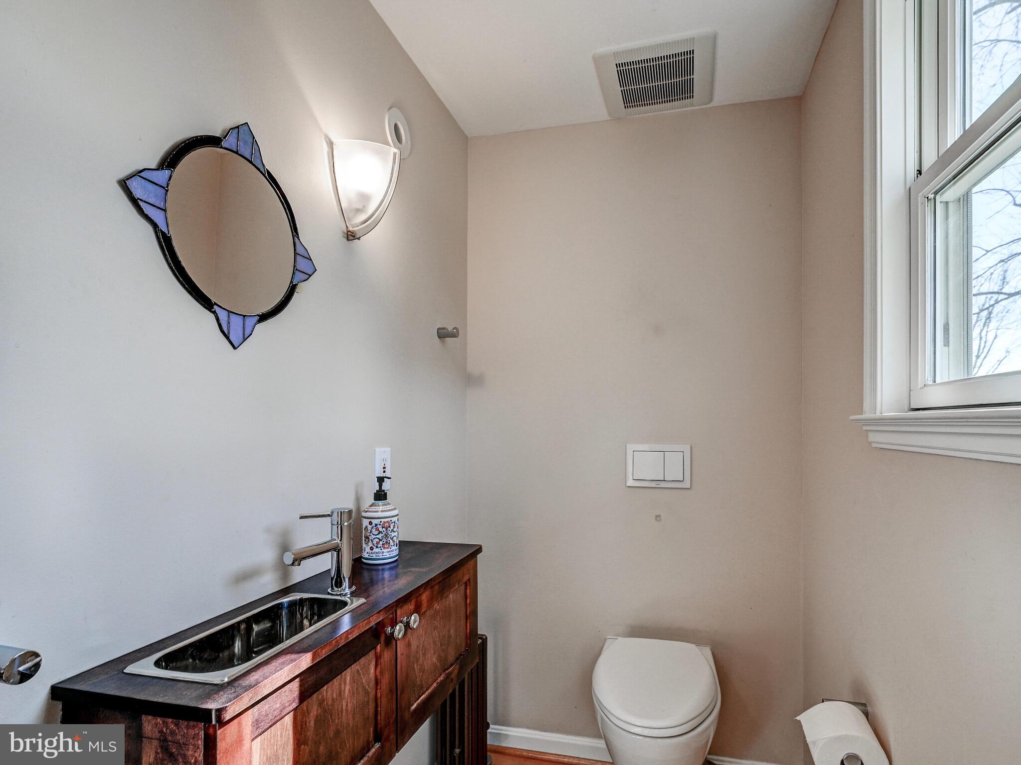207 Cedarcroft Road Baltimore, MD 21212 - Photo 23 of 50 a bathroom with a toilet a sink and mirror