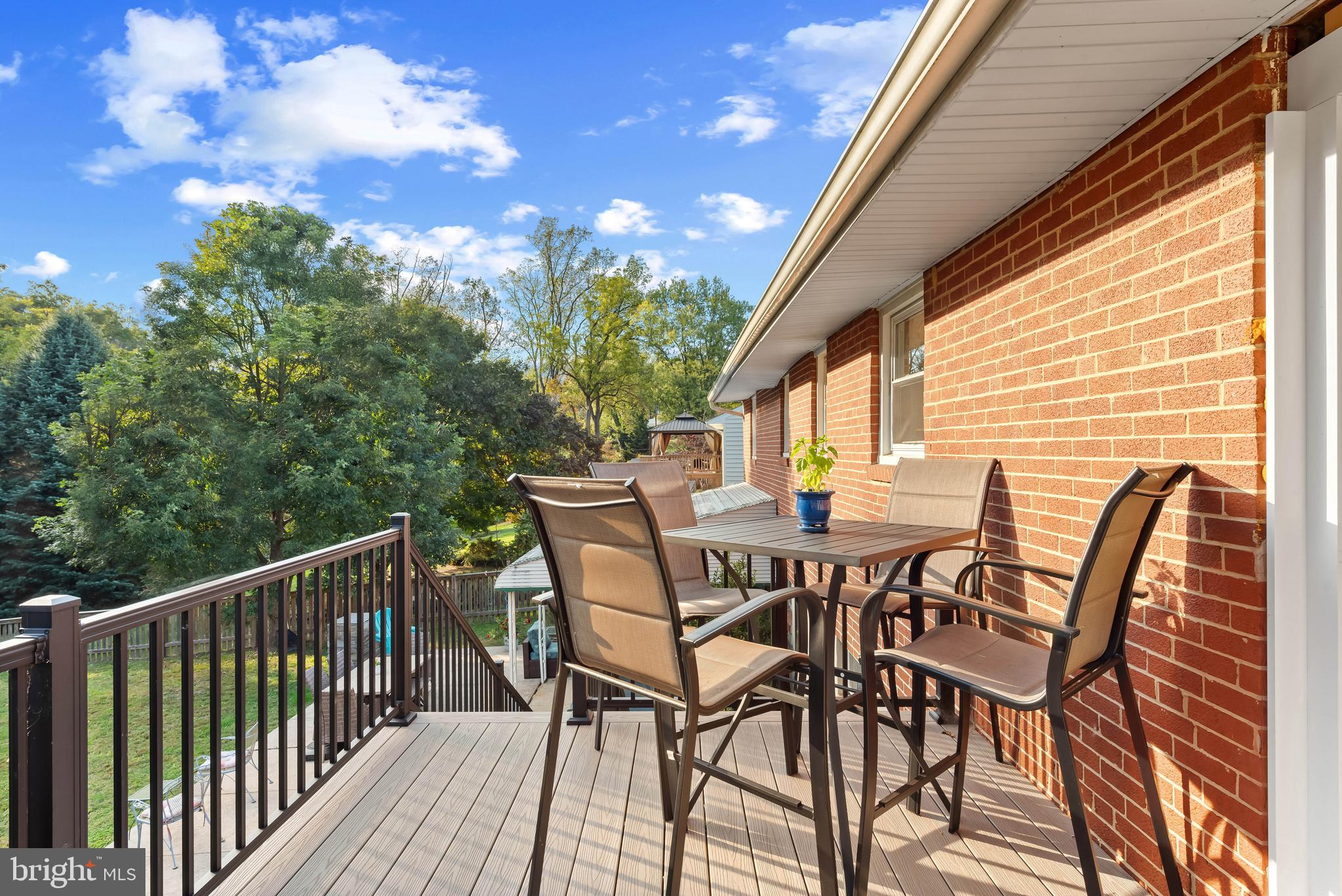 419 Wake Robin Drive Cockeysville, MD 21030 - Photo 19 of 20 a view of a patio with table and chairs with wooden floor and fence
