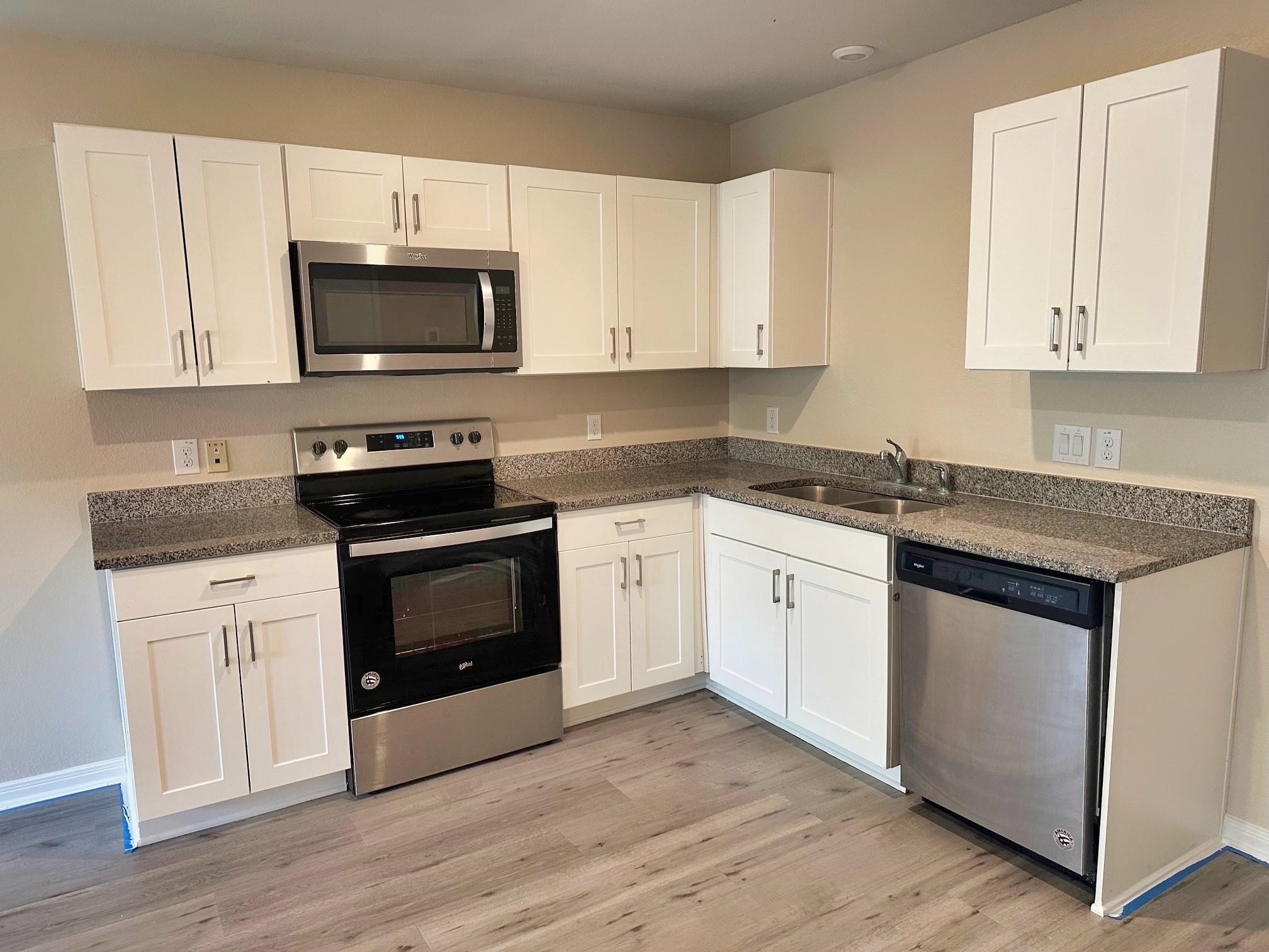 175 Mesquite Livingston, TX 77351 - Photo 7 of 14 a kitchen with white cabinets and black appliances