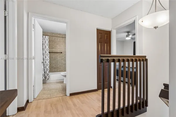 a view of a hallway with wooden floor and staircase