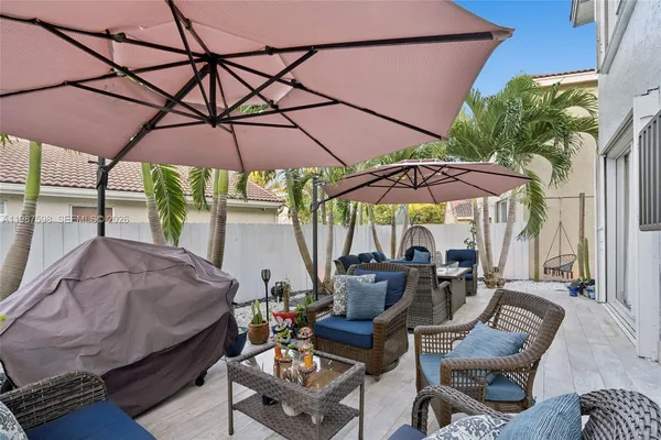 a view of patio with chairs and table under an umbrella