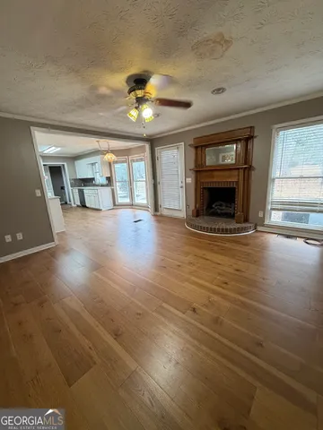 a view of an empty room with a fireplace and a window