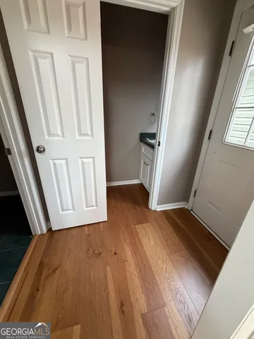 a view of a kitchen with a stove wooden cabinets and a floor to ceiling window