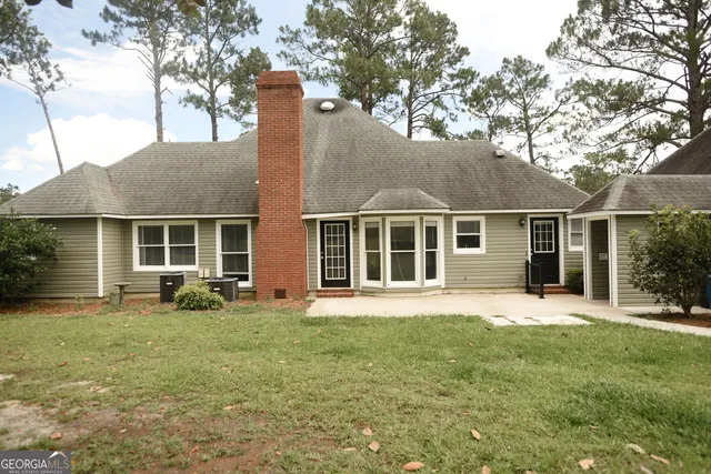 a front view of a house with a yard and sitting space