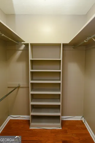 a view of walk in closet with empty racks