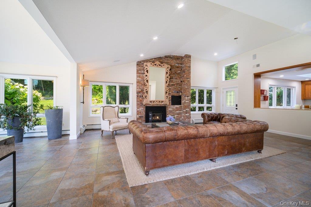 237 Mineral Springs Road Highland Mills, NY 10930 - Photo 32 of 32 Living area featuring high vaulted ceiling, a brick fireplace, recessed lighting, and a baseboard radiator
