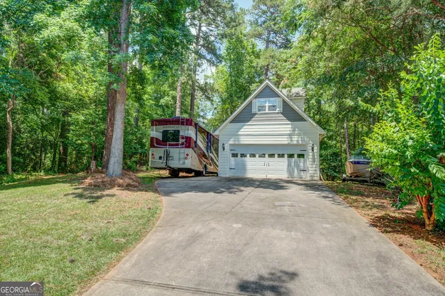 a view of a house with a yard and large tree