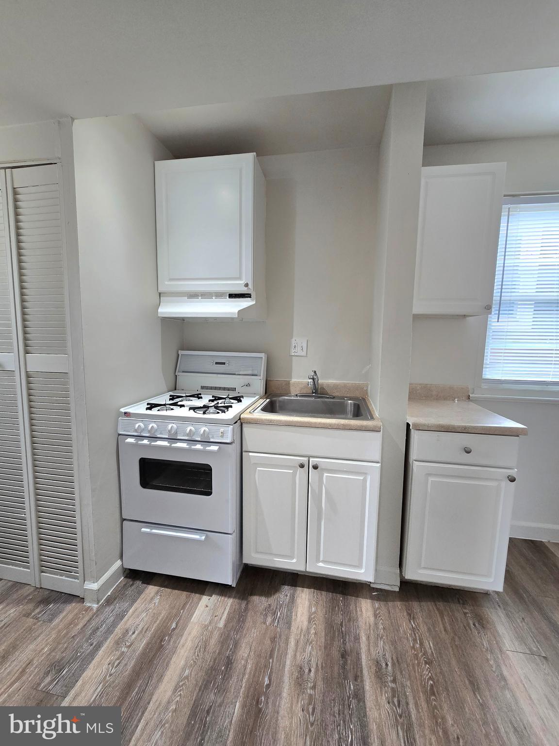 272 56th Street Northeast Washington, DC 20019 - Photo 6 of 13 a kitchen with white cabinets and white appliances