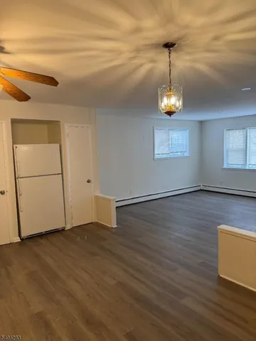 a view of empty room with wooden floor and window
