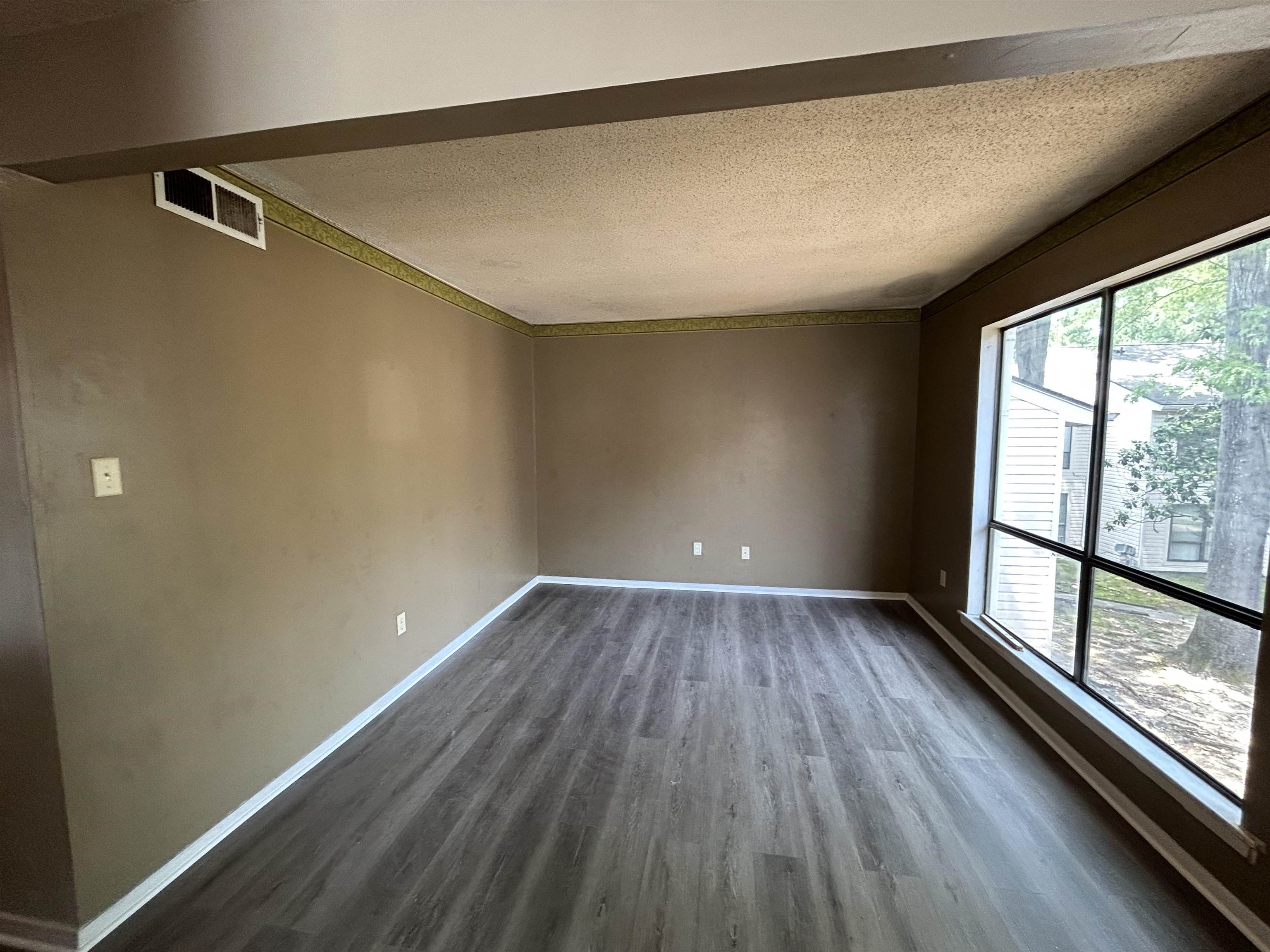 2800 Clarke Road, Unit 2 Memphis, TN 38115 - Photo 15 of 18 Spacious interior room featuring large picture windows, wood-finish flooring, neutral wall paint, and white baseboards