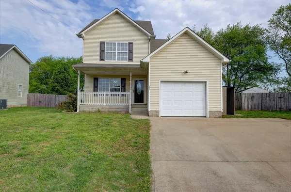 a view of front of house with a yard and garage