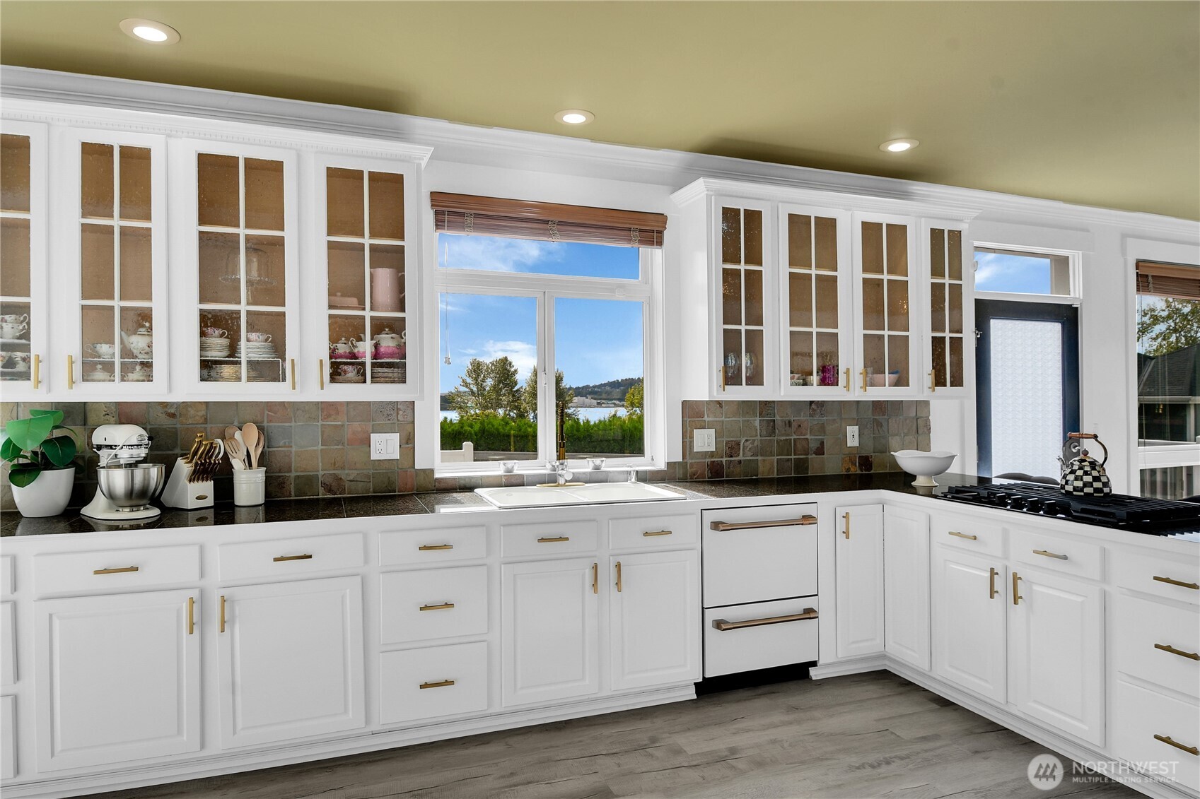 1011 North 27th Place Renton, WA 98056 - Photo 11 of 40 a kitchen with granite countertop a sink and cabinets
