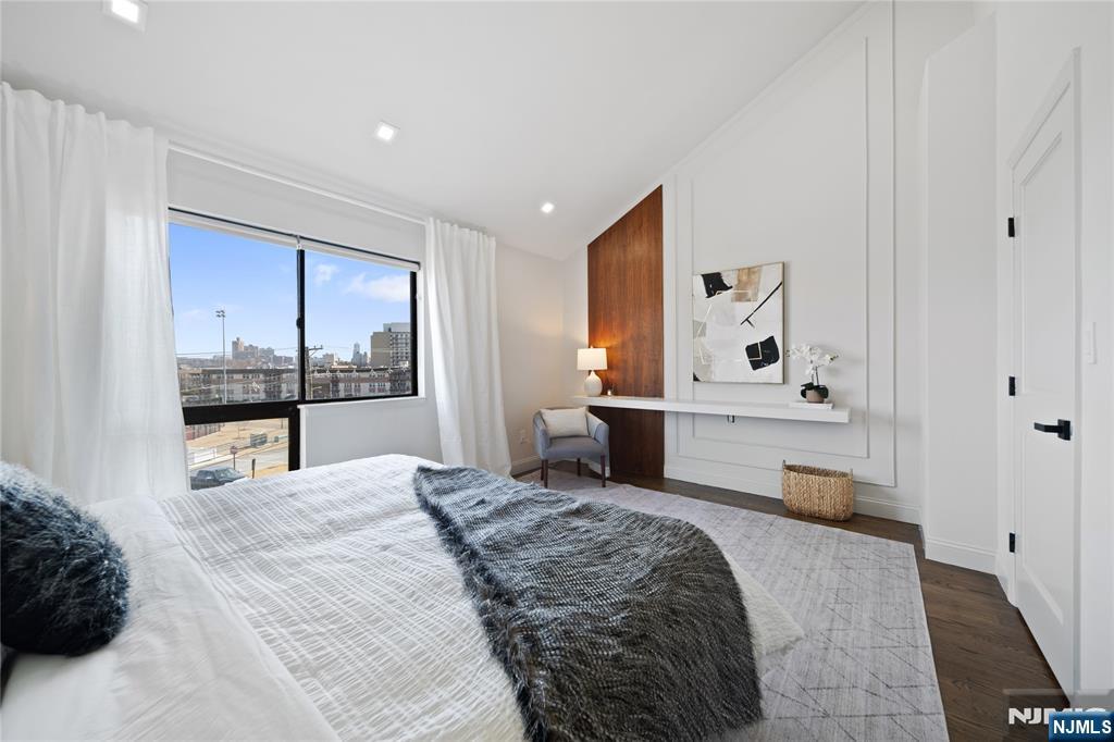 1110 River Road, Unit 102 Edgewater, NJ 07020 - Photo 11 of 18 a bedroom with a bed and dresser with mirror