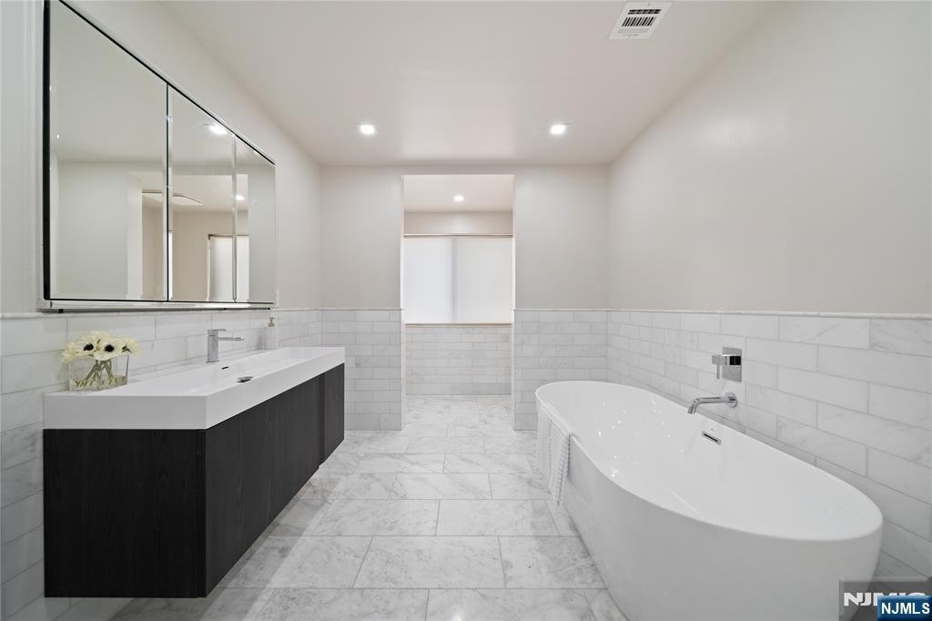 1110 River Road, Unit 102 Edgewater, NJ 07020 - Photo 14 of 18 a bathroom with a bathtub and a sink