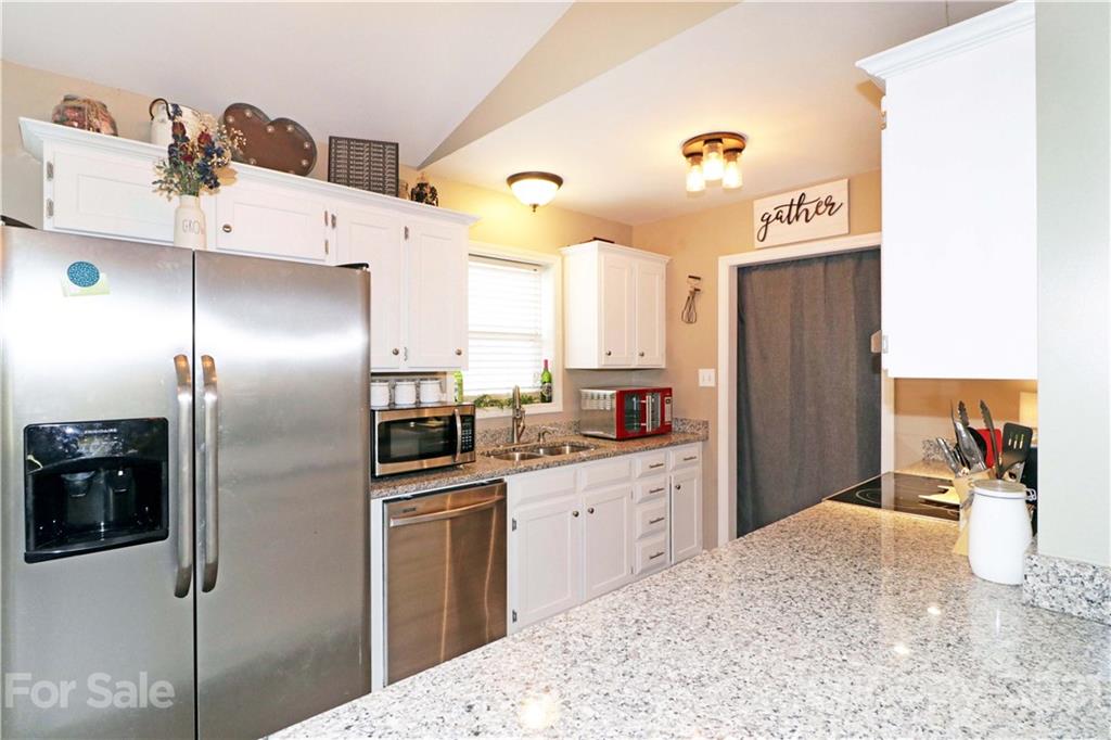 1045 Tabor Road Olin, NC 28660 - Photo 11 of 44 a kitchen with stainless steel appliances a refrigerator sink and cabinets