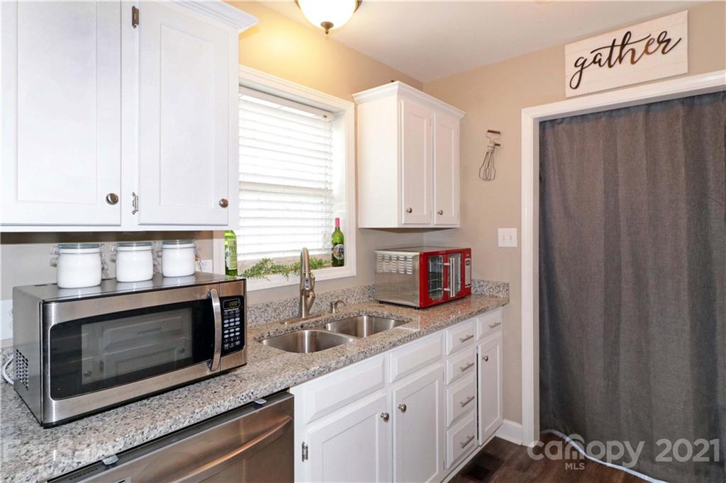 1045 Tabor Road Olin, NC 28660 - Photo 12 of 44 a kitchen with stainless steel appliances granite countertop a stove a microwave and a white cabinets