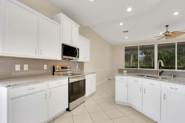 a kitchen with white cabinets and white appliances