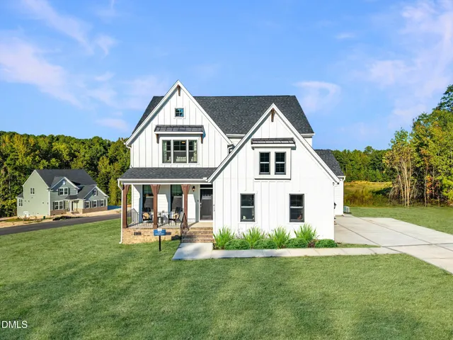 a front view of a house with a garden and yard