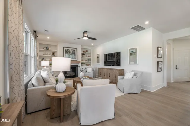 a living room with furniture kitchen view and a flat screen tv