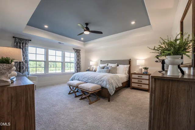 a spacious bedroom with a bed a chandelier and a large window