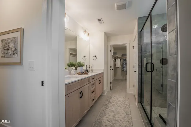 a bathroom with a double vanity sink toilet and shower