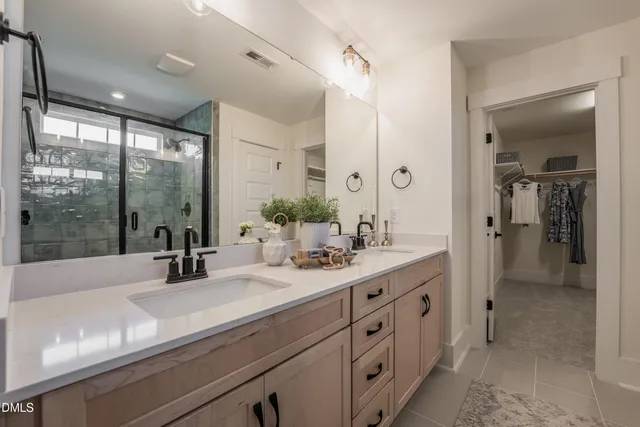 a bathroom with double vanity and a mirror