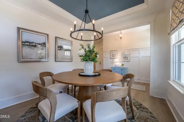 a view of a dining room with furniture wooden floor and a chandelier