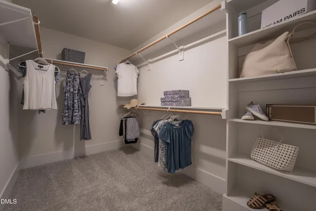 a view of walk in closet with clothes and shoes