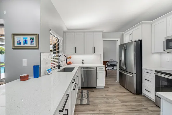 a kitchen with cabinets stainless steel appliances and a counter space