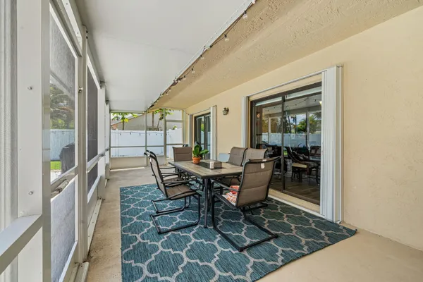 a view of swimming pool with lounge chair and dinning table under an umbrella