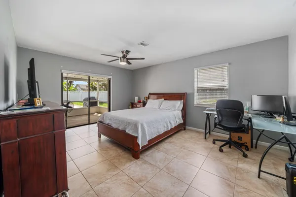 a spacious bedroom with a bed and a flat screen tv