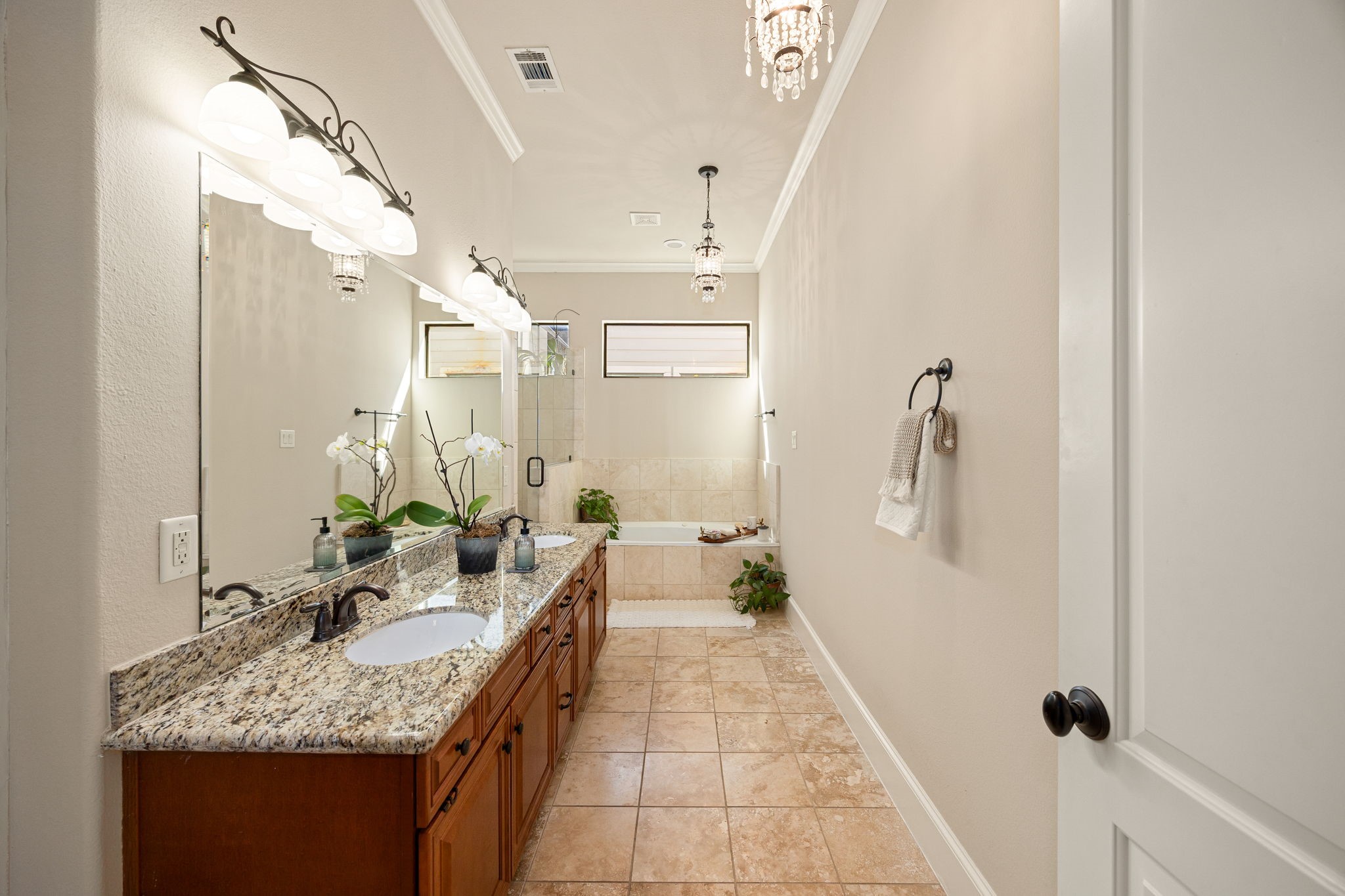 821 Lester Street Houston, TX 77007 - Photo 18 of 44 Gorgeous bathroom features a double vanity with granite countertops and elegant chandeliers.