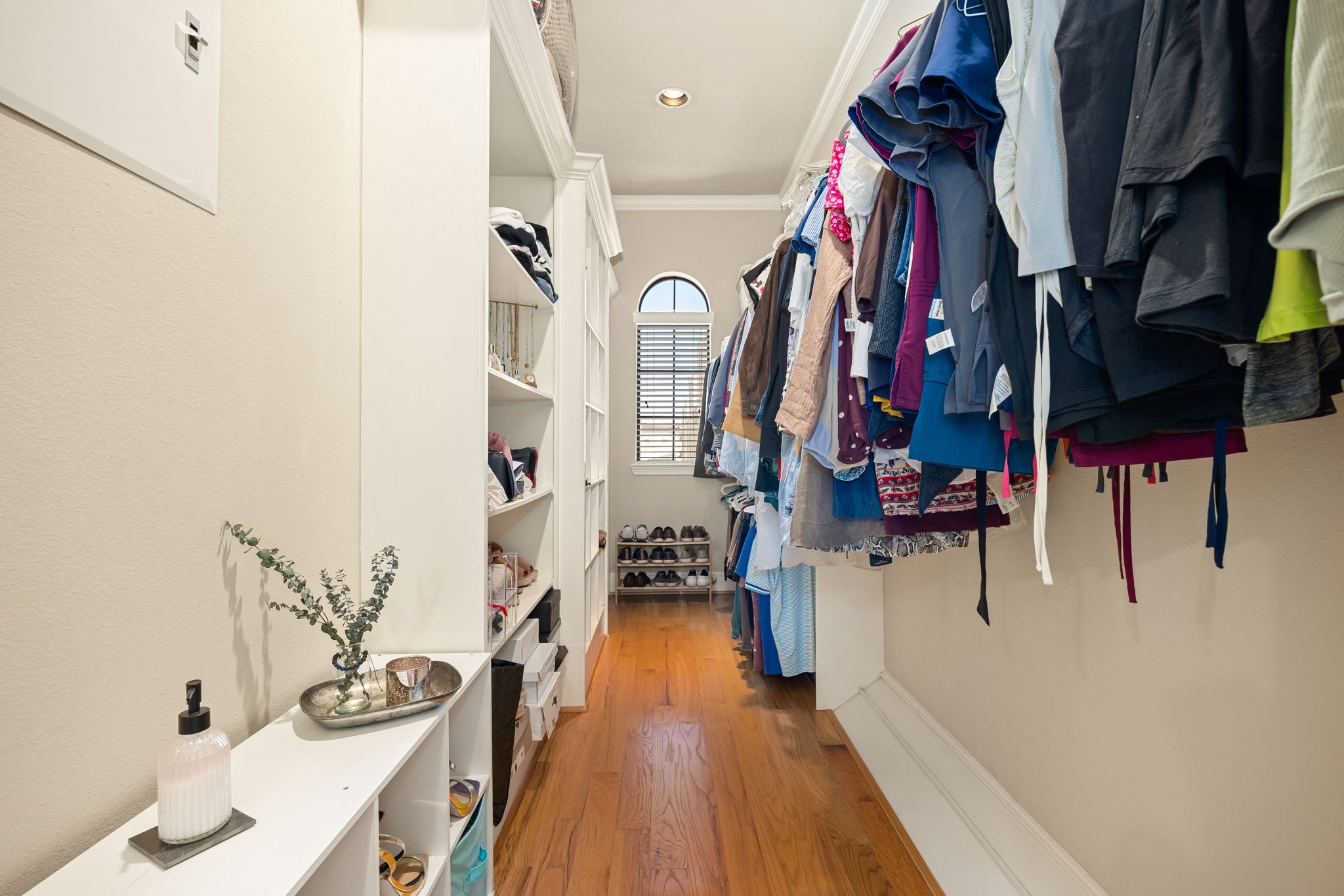 821 Lester Street Houston, TX 77007 - Photo 20 of 44 Large walk-in closet with built-in shelves for storage and ample hanging space. A window at the end provides natural light, creating an inviting atmosphere.