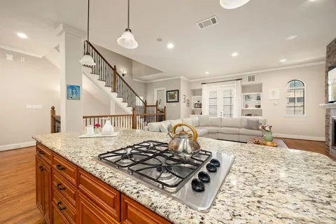 a kitchen with stainless steel appliances granite countertop a kitchen island a stove and a wooden floors
