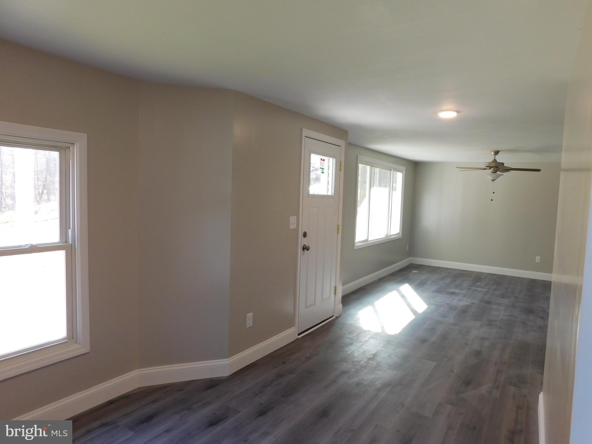 855 Shippy Road Manns Choice, PA 15550 - Photo 3 of 7 an empty room with wooden floor and windows