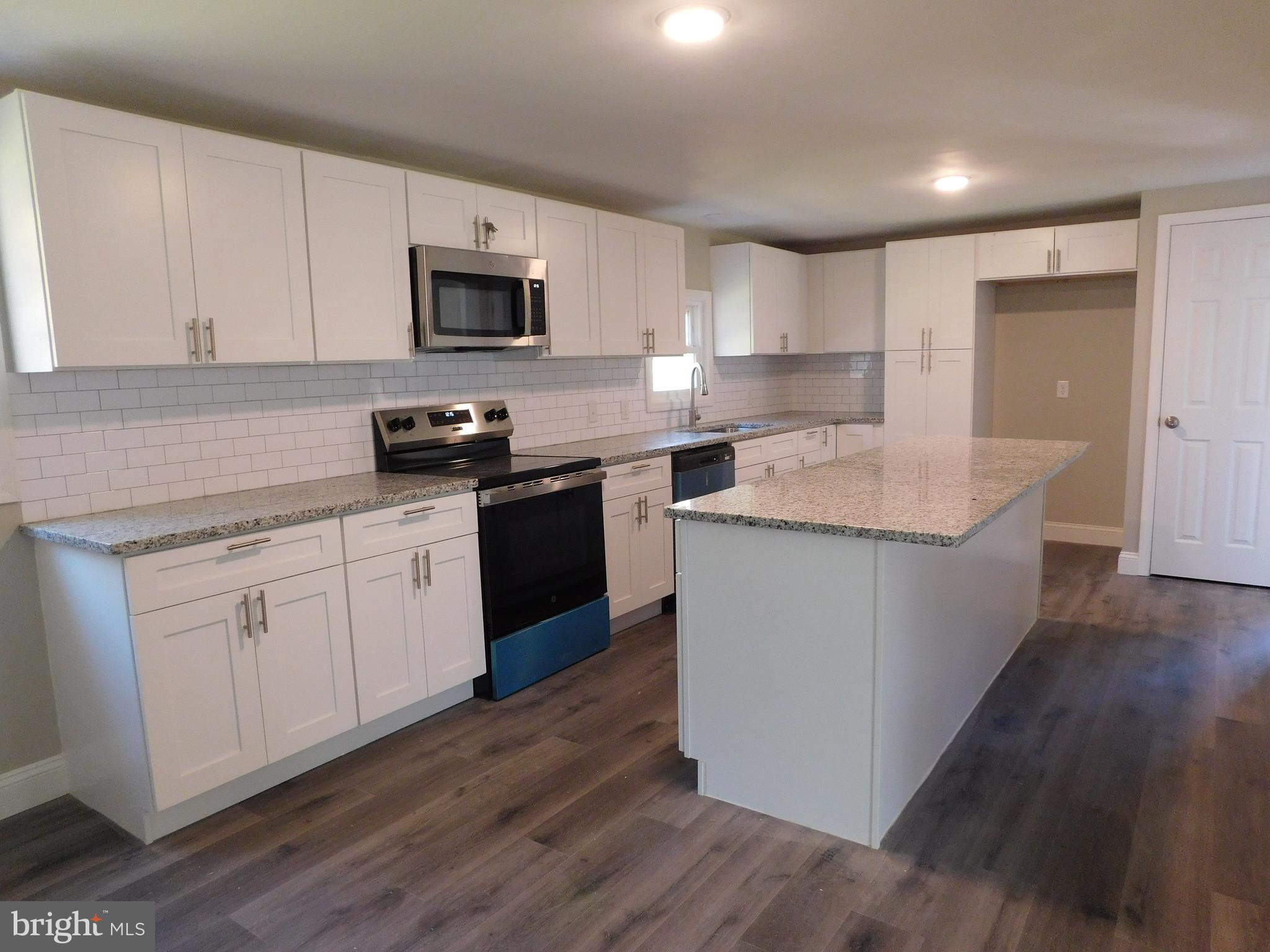 855 Shippy Road Manns Choice, PA 15550 - Photo 4 of 7 a kitchen with granite countertop white cabinets sink and stainless steel appliances