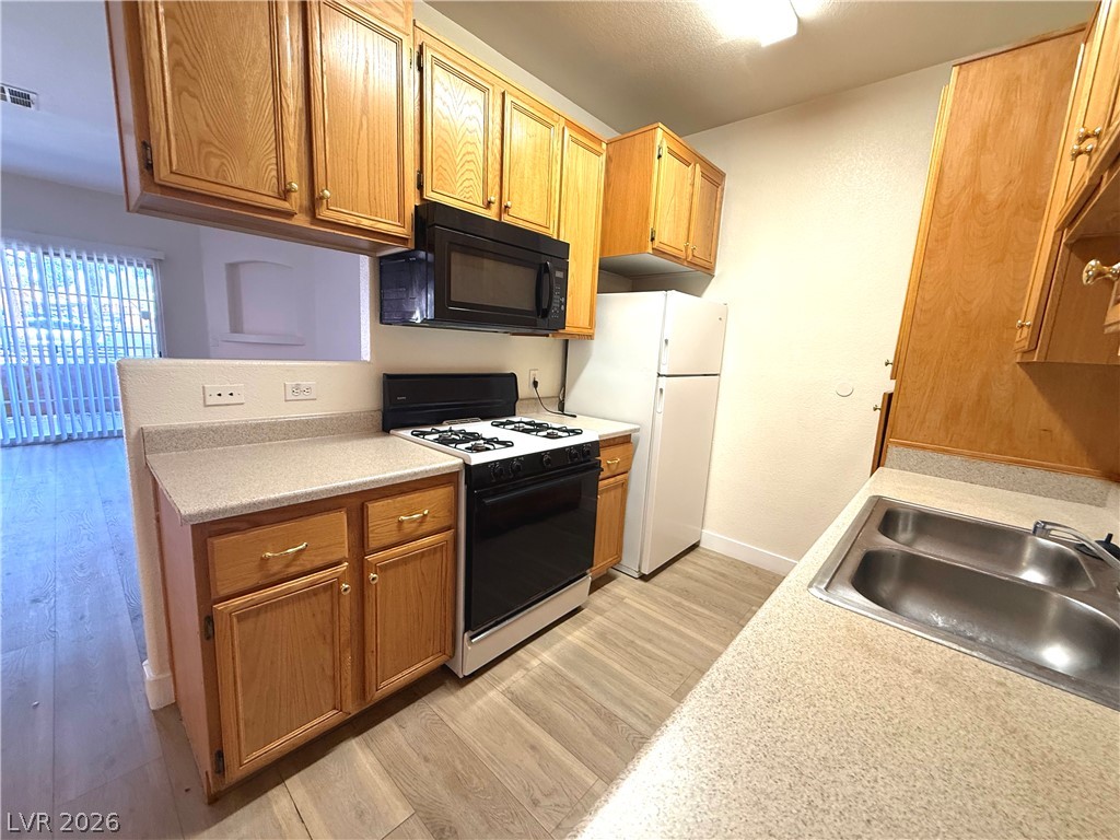 4730 East Craig Road, Unit 1164 Las Vegas, NV 89115 - Photo 4 of 14 A well-appointed kitchen features ample counter space, rich wood cabinetry, and essential appliances.