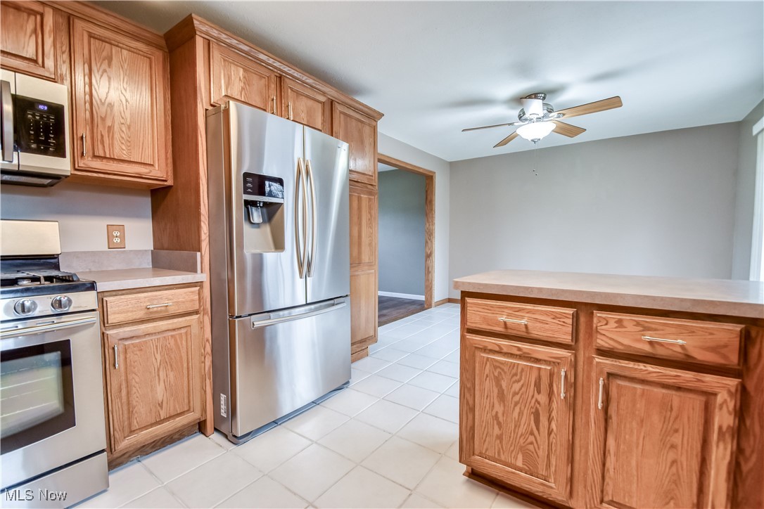 5618 Dolphin Road Mentor, OH 44060 - Photo 14 of 46 Kitchen with stainless steel appliances, light countertops, brown cabinets, light tile patterned floors, and ceiling fan