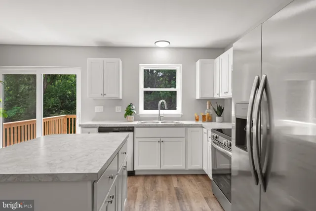 a kitchen with a center island appliances wooden floor and a window