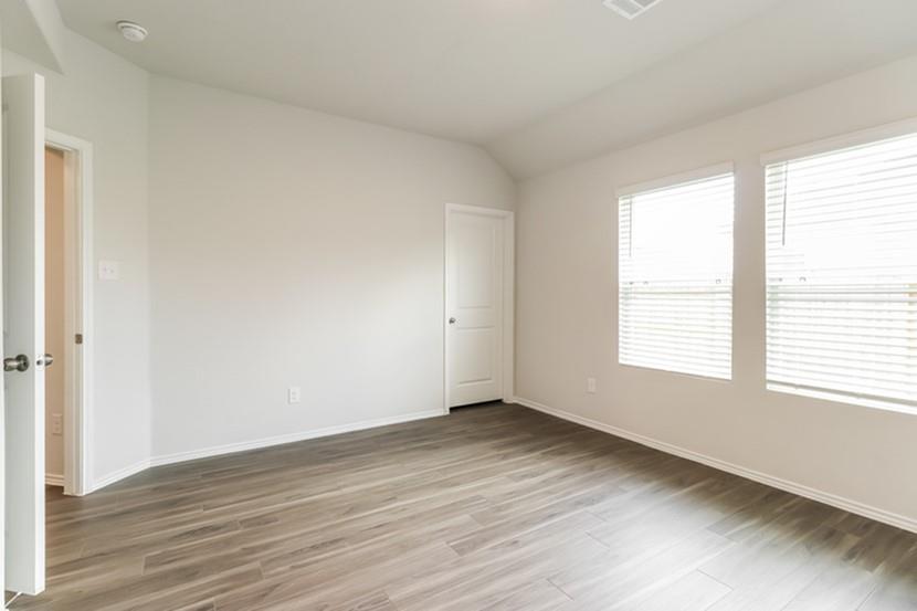 113 Arango Way Everman, TX 76140 - Photo 8 of 13 a view of an empty room with wooden floor and a window