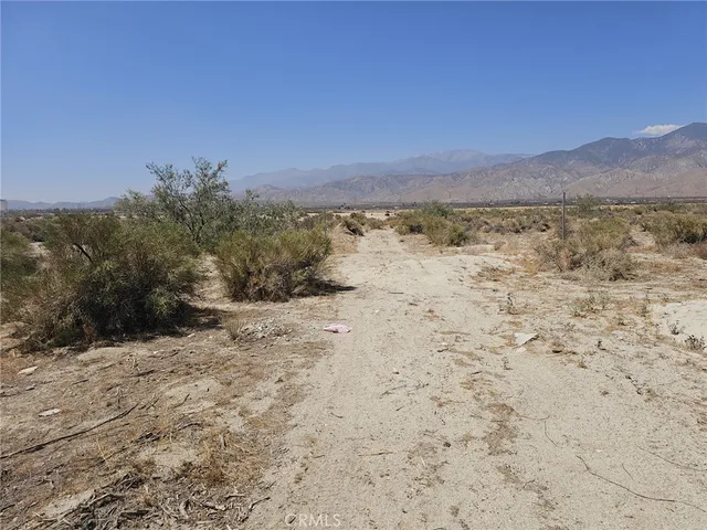 a view of a dry yard with mountains in the background