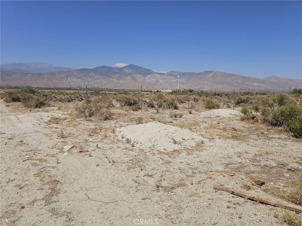 a view of a dry yard with mountains in the background